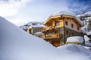 蒂涅Chalet Monte Bianco的雪覆盖的建筑,在雪中设有阳台