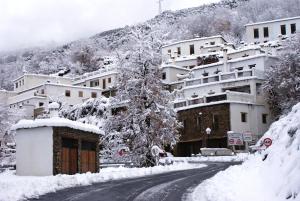 布维翁Casa De La Ermita的一座有建筑物的小镇上一条有雪覆盖的街道