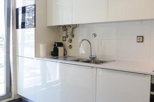 里斯本Lisbon White Cozy Apartment的厨房配有白色橱柜和水槽
