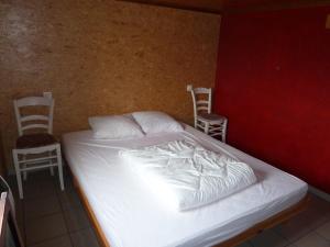 DoischeChalet Pimpernel的一张位于带两把椅子和白色床垫的房间的床铺