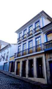 欧鲁普雷图奥普拉太阳酒店的蓝色和白色的建筑,在街上设有阳台