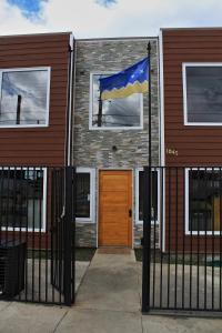 纳塔列斯港Hostal America en Puerto Natales的国旗在房子前面飘扬