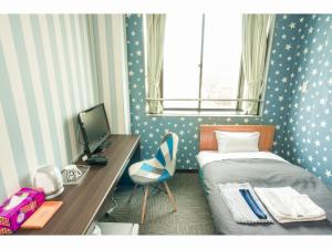 伊那市伊那酒店的一间卧室配有一张床和一张带电脑的书桌