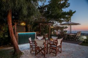 拉格尼西Villa Sunrise Lagonisi的庭院里配有桌椅和遮阳伞