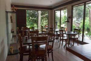 茂物萨瓦萨拉克别墅酒店的用餐室设有桌椅和窗户。