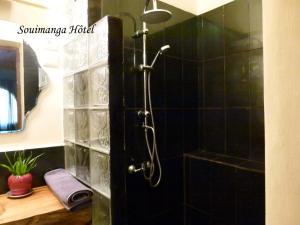 安齐拉贝SOUIMANGA-HOTEL的浴室设有黑色瓷砖墙和淋浴。