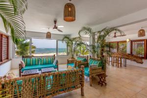迪亚尼海滩Tequila Sunrise Beach Cabana - Diani Beach的客厅配有桌椅,享有海景