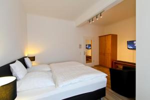 格拉德贝克Hotel Jammerkrug的卧室配有白色的床和电视。