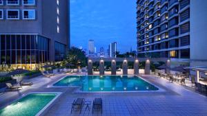 新加坡Carlton Hotel Singapore的一座建筑物中央的游泳池