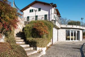 MalgessoTenuta La Vigna的通往带绿色窗户的白色房屋的楼梯
