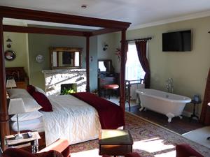 邓法纳希The Mill的一间卧室配有一张床和一个浴缸。
