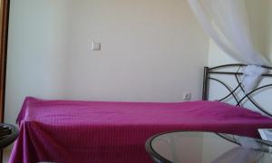 诺亚福克海滨乡村民宿的一间设有玻璃桌和紫色毯子的房间
