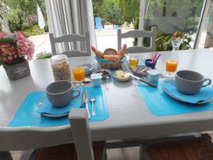 Vergt-de-BironLe Chalet Bleu的一张桌子,上面有两杯,还有一盘早餐食品