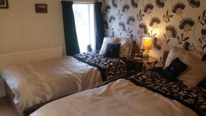 文特诺Kingsmede Bed & Breakfast的一间卧室设有两张床和窗户。