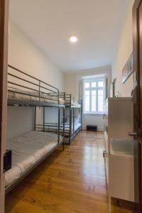 蒙特卡罗埃斯托里尔Change The World Hostels - Cascais - Estoril的客房设有两张双层床,铺有木地板。