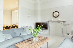 爱丁堡Ramsay Gardens - Grand 4-Bedroom Apartment Next To Castle的客厅配有蓝色的沙发和桌子