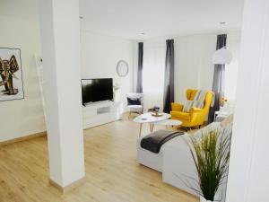 塞维利亚Apartamento El Barranco的带沙发和电视的白色客厅