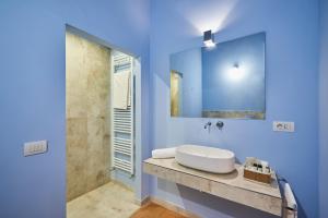 锡耶纳索奇尼别墅旅馆的蓝色的浴室设有水槽和镜子