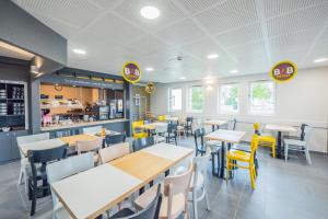 博库泽B&B HOTEL Angers 2 Université的餐厅内带桌椅的用餐室