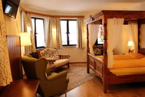 克拉根福索嫩霍夫酒店的一间卧室配有四柱床和椅子