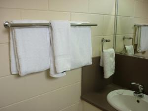 楠伯南博汽车旅馆 的浴室提供白色毛巾、水槽和镜子