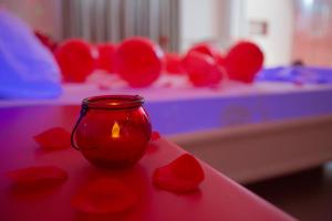 桑托斯骊威拉斯汽车旅馆（仅限成人）的红玫瑰桌子上的玻璃瓶里的蜡烛