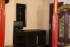 圣吉吉普里邦加海滩小屋酒店的一间设有门、电视和书桌的房间