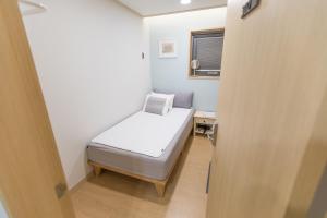 济州市布瑞克旅馆的一间小卧室,配有床和窗户