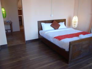 BaudhatinchuleBodhi Apartment hotel的一间卧室设有一张大床,铺有木地板