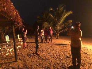 AkwidaThe Akwidaa Inn的一群人晚上站在海滩上