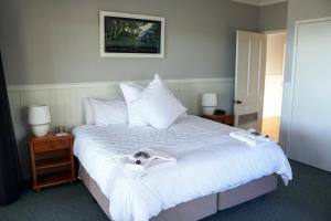 Vacy山谷景豪华度假酒店的卧室配有一张带白色床单和枕头的大床。