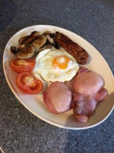 科夫堡Jonti Bed And Breakfast的包括鸡蛋肉和蘑菇的早餐食品