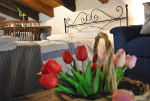孔韦尔萨诺Mansarda romantica "Il nido delle rondini"的一间卧室配有一张红色和粉红色郁金香的床