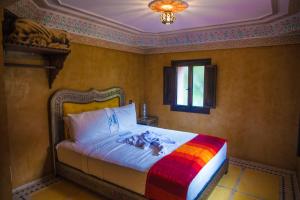 伊姆利尔Targa Imoula的一间卧室配有一张带彩色毯子的床
