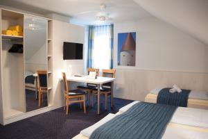 帕绍维库斯旅馆的酒店客房带一张床铺、一张书桌和一间卧室