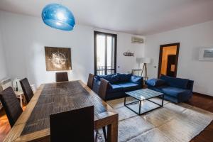 蒙德罗LuminHouse Mondello Zibibbo的客厅配有桌子和蓝色沙发