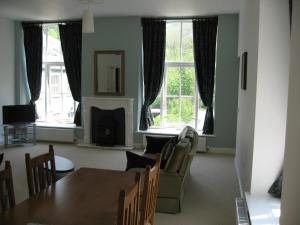 泰德斯韦尔Litton Mill Apartment的客厅配有桌椅和窗户。