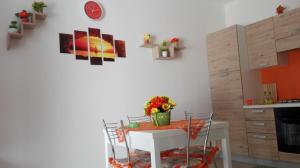 伯吉维奇Casa Vacanze Sottovento的厨房配有白色的桌椅
