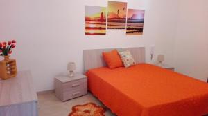 伯吉维奇Casa Vacanze Sottovento的一间卧室配有一张带橙色床罩的床
