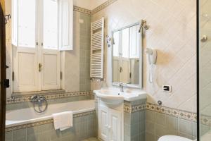罗马Nice Apartment Navona Square的一间带水槽、浴缸和镜子的浴室