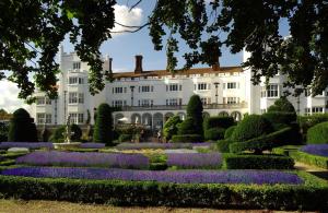 马洛丹尼斯菲尔德别墅酒店&SPA的白色建筑前方鲜花盛开的花园