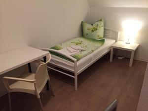 新勃兰登堡Pension ,,Vier Tore''的小房间设有一张床、一张桌子和一张书桌