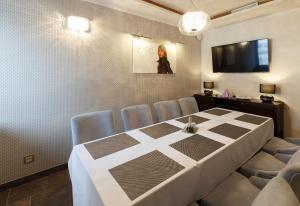 斯尼纳Hotel Bystrá的一间带桌椅和电视的用餐室