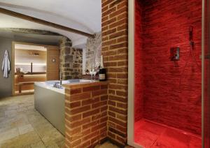 基安蒂盖奥勒Villa Sofia & Spa的一间带红砖墙和浴缸的浴室