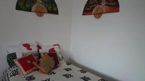 桑托斯Studio mobiliado的一张带东方枕头和壁画的床
