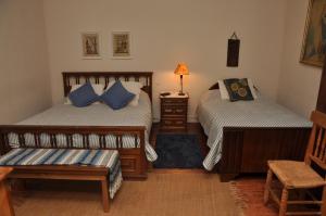 库里科Sta. Marta B&B的一间卧室配有两张床、椅子和一盏灯。