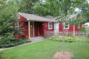 腓尼基Phoenicia Lodge的院子里有树的红色房子