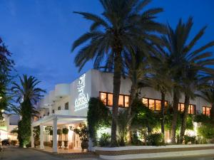 维拉卡莫纳阳台酒店的前面有棕榈树的酒店