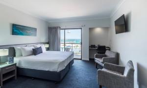 杰拉尔顿海洋中心酒店的酒店客房设有一张床和一个阳台。