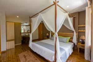 乌库拉斯西沙滩旅馆的一间卧室配有一张带天蓬的床